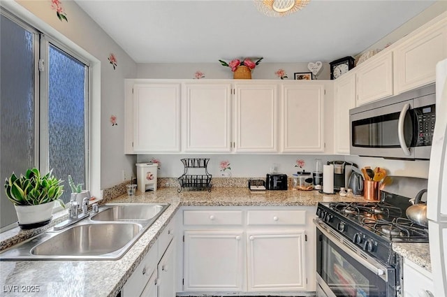 kitchen with a sink, white cabinetry, and stainless steel appliances