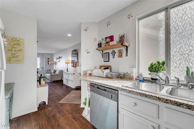 kitchen with dark wood-style floors, white cabinetry, a sink, light countertops, and stainless steel dishwasher