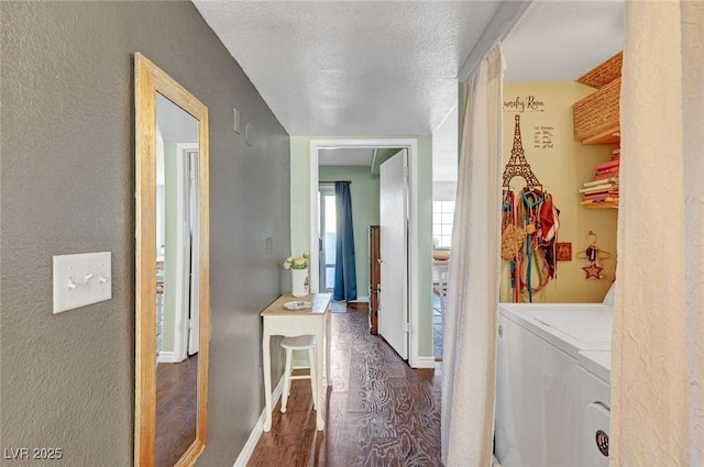 clothes washing area featuring a textured ceiling, dark wood-style floors, baseboards, laundry area, and washing machine and clothes dryer