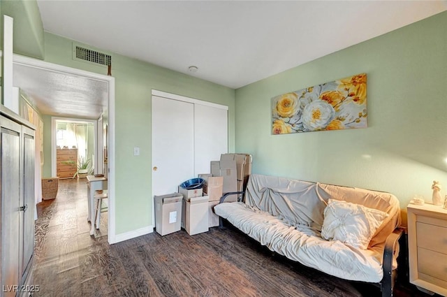 living area with visible vents, dark wood-type flooring, and baseboards