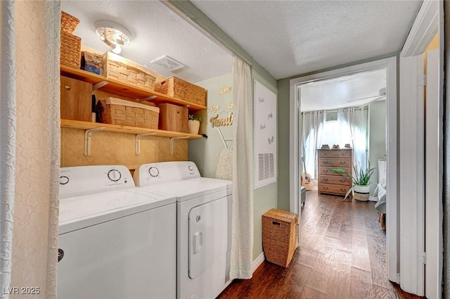 clothes washing area featuring dark wood finished floors, laundry area, washer and dryer, and a textured ceiling