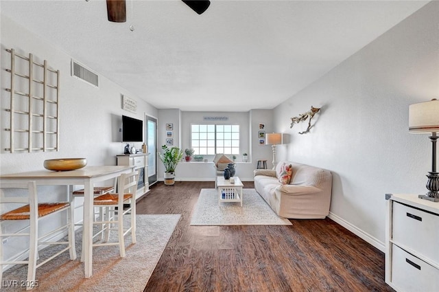 living area with ceiling fan, visible vents, baseboards, and wood finished floors