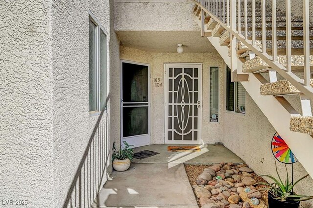 entrance to property featuring stucco siding