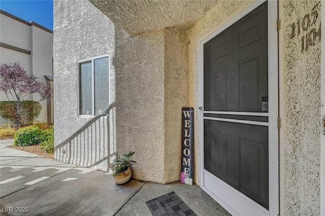 entrance to property featuring stucco siding