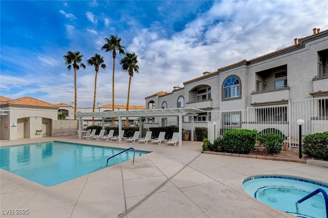 pool featuring a hot tub, a patio, and fence