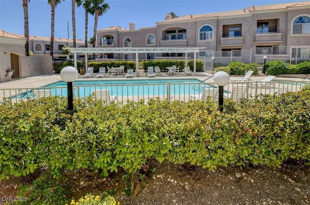 community pool with a patio and fence