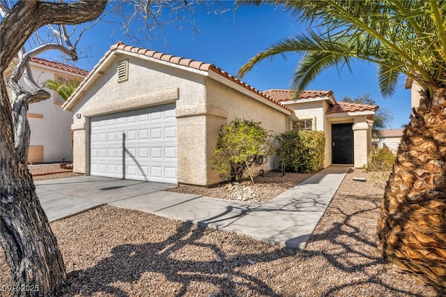 mediterranean / spanish-style house with stucco siding, concrete driveway, an attached garage, and a tiled roof