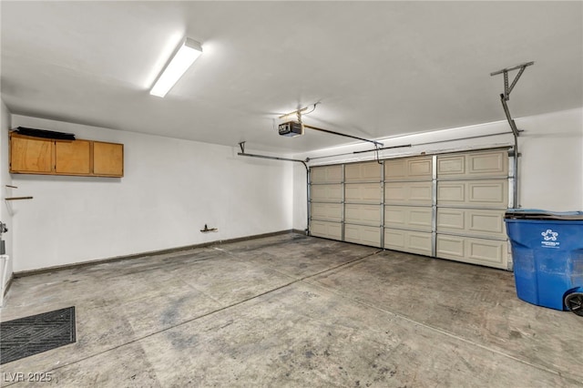 garage featuring visible vents, baseboards, and a garage door opener