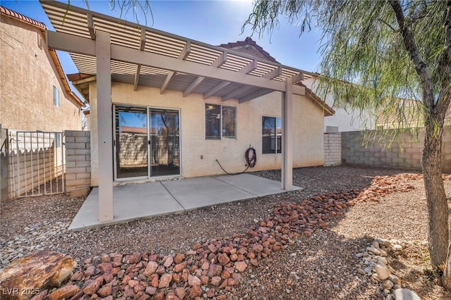 rear view of house featuring stucco siding, a patio, a pergola, and a fenced backyard