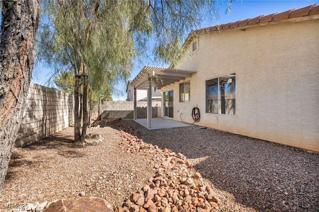 back of property with a patio area, a fenced backyard, a pergola, and stucco siding