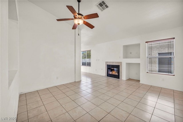 unfurnished living room with light tile patterned floors, a fireplace, visible vents, and ceiling fan