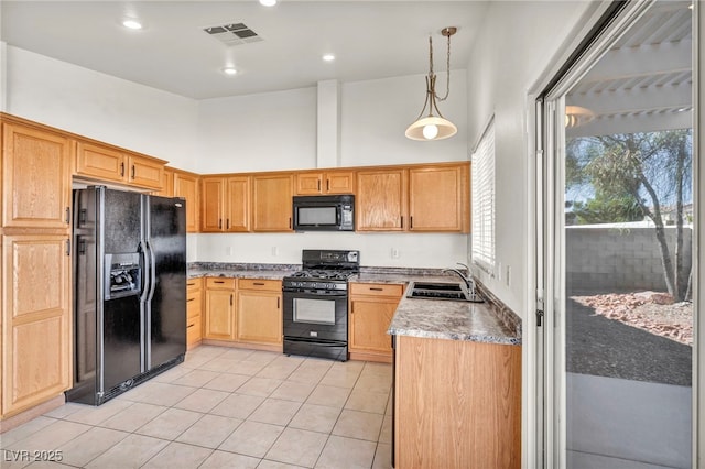 kitchen with visible vents, black appliances, a sink, a high ceiling, and light tile patterned floors