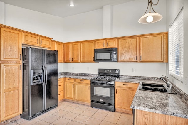 kitchen with light tile patterned floors, a high ceiling, a sink, black appliances, and pendant lighting