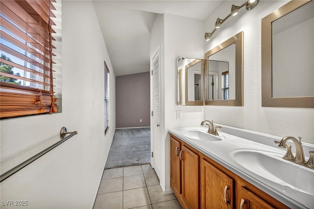 bathroom with a sink, double vanity, and tile patterned floors