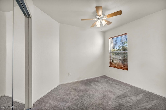 carpeted empty room with a ceiling fan