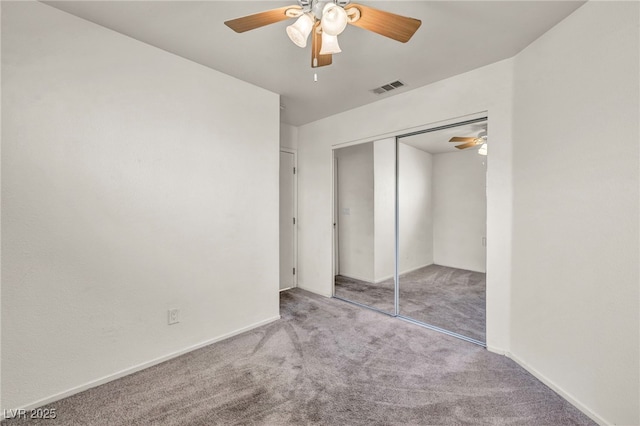 unfurnished bedroom with visible vents, a closet, carpet floors, baseboards, and ceiling fan