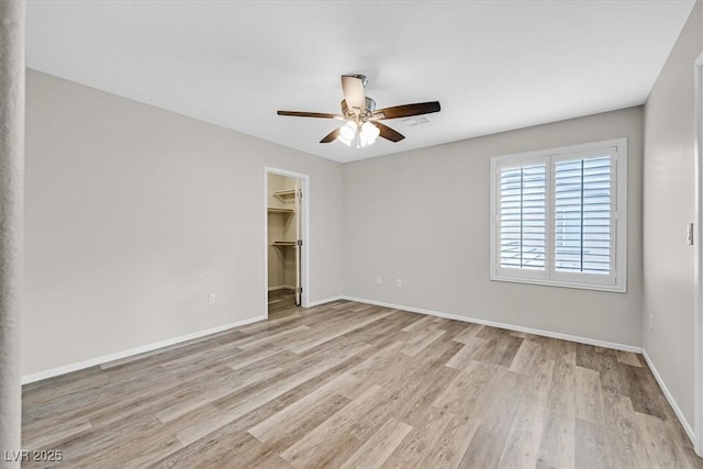 unfurnished room with baseboards, light wood finished floors, and ceiling fan