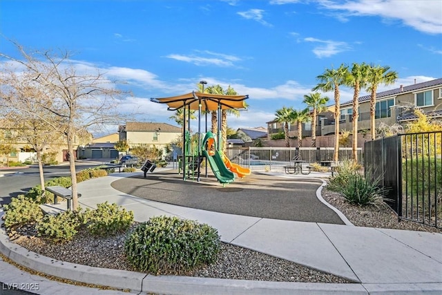 communal playground with a residential view and fence