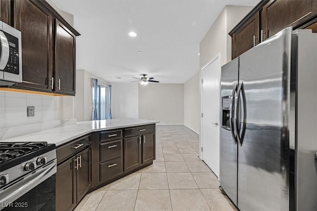 kitchen featuring ceiling fan, decorative backsplash, a peninsula, light tile patterned flooring, and stainless steel appliances