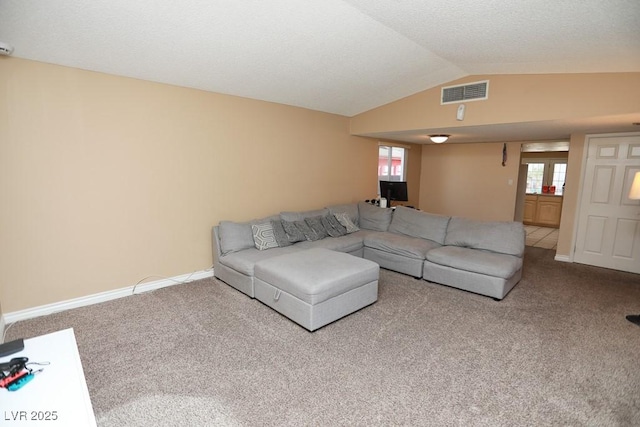 carpeted living area featuring visible vents, lofted ceiling, and baseboards