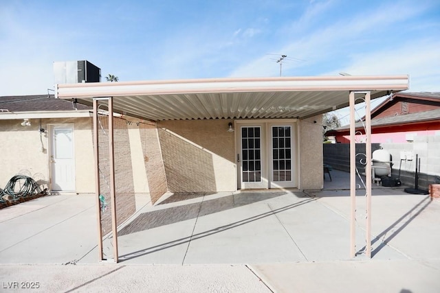 view of patio featuring french doors, central AC, and fence