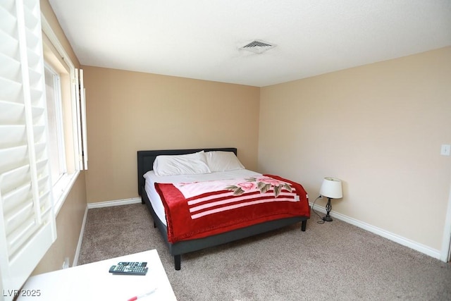 carpeted bedroom with visible vents and baseboards