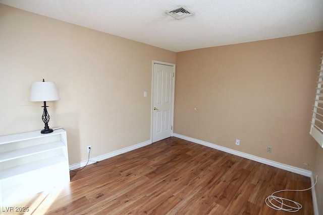 unfurnished bedroom with visible vents, baseboards, and wood finished floors