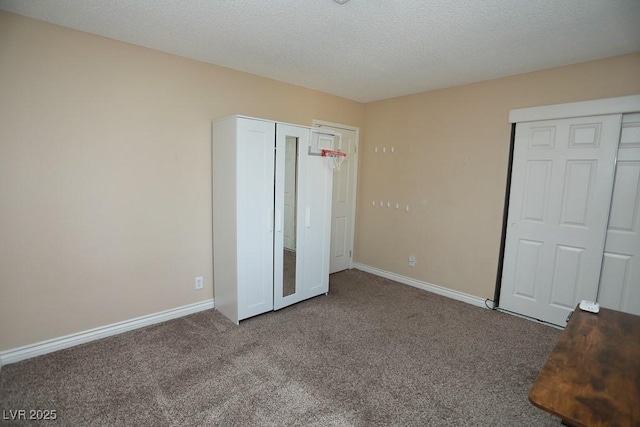 unfurnished bedroom with carpet, baseboards, and a textured ceiling