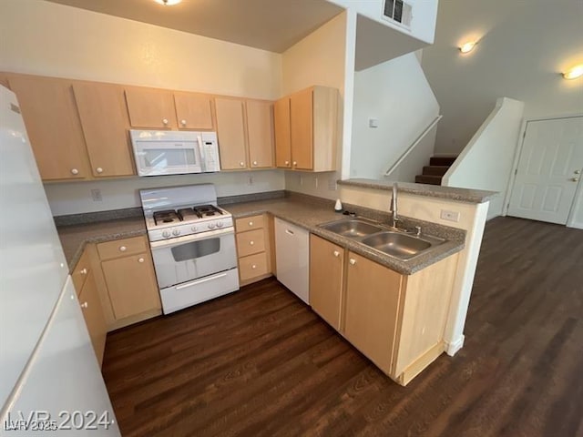 kitchen featuring a sink, white appliances, a peninsula, and light brown cabinetry