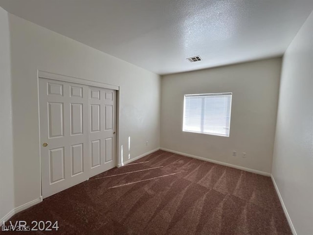 unfurnished bedroom featuring a closet, visible vents, baseboards, and carpet