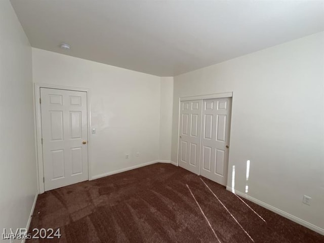 unfurnished bedroom with a closet, baseboards, and carpet floors