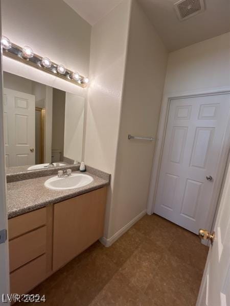 bathroom featuring visible vents, baseboards, and vanity