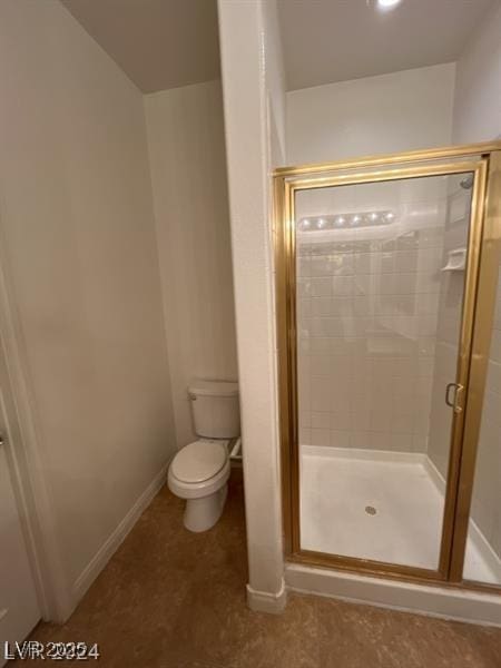 bathroom featuring a stall shower, toilet, and baseboards