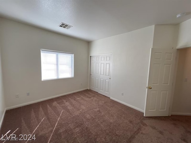 carpeted empty room with visible vents and baseboards