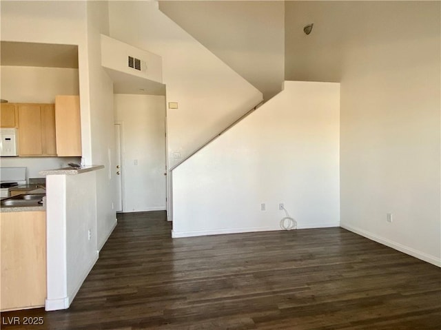 interior space with dark wood-type flooring, baseboards, and visible vents