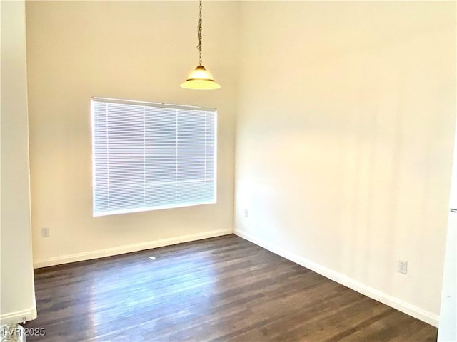 empty room with dark wood finished floors and baseboards