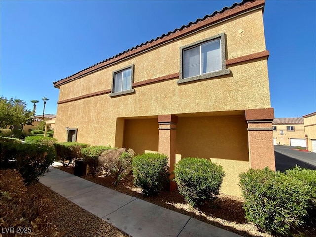 view of property exterior featuring stucco siding and a tile roof