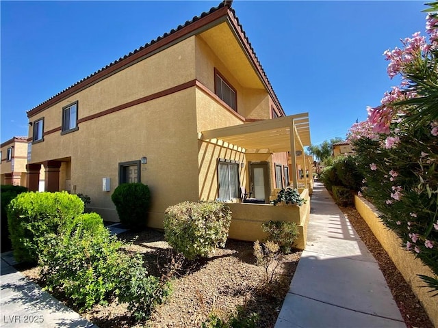 view of side of home with a pergola and stucco siding