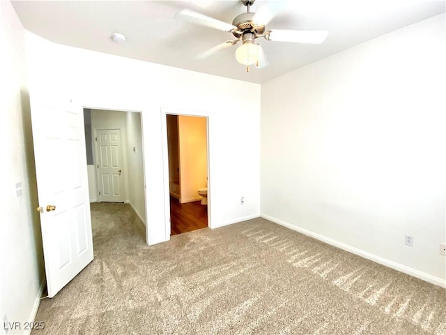 unfurnished bedroom with connected bathroom, baseboards, carpet floors, and ceiling fan