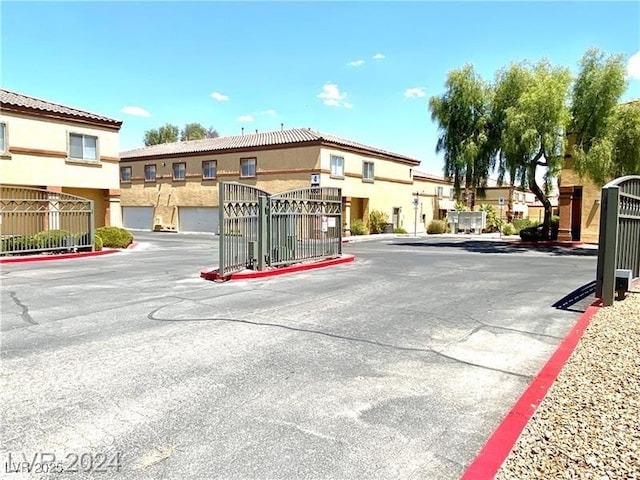 view of road featuring a gated entry, curbs, and a gate