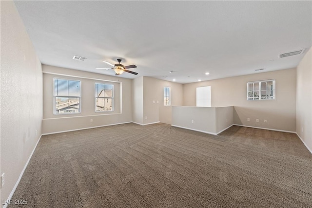 carpeted spare room featuring visible vents and baseboards