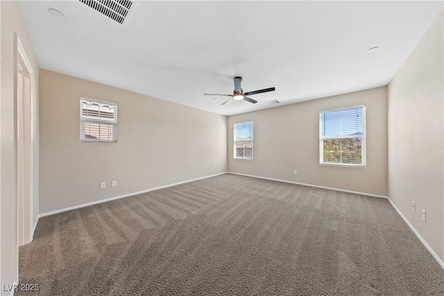 spare room with carpet flooring, baseboards, visible vents, and a ceiling fan