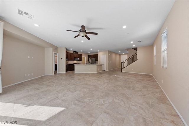 unfurnished living room with recessed lighting, visible vents, baseboards, and stairs