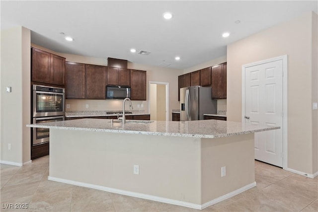 kitchen featuring dark brown cabinets, stainless steel appliances, visible vents, and a sink