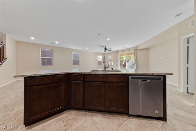 kitchen featuring light stone countertops, recessed lighting, a sink, dark brown cabinetry, and stainless steel dishwasher