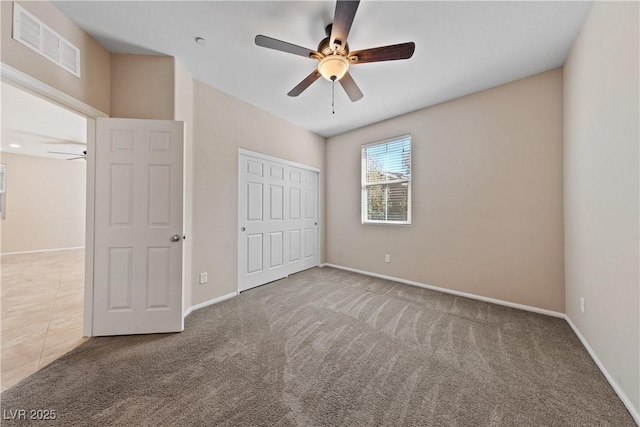 unfurnished bedroom featuring visible vents, ceiling fan, baseboards, carpet, and a closet