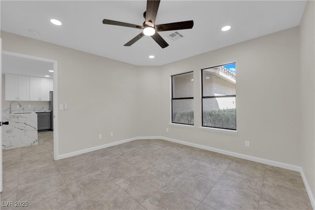 spare room featuring a sink, visible vents, baseboards, and recessed lighting