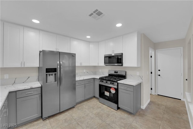 7803 Canoe Ln, Las Vegas, NV 89145 - kitchen with stainless steel appliances, gray cabinets, light stone counters, white cabinets, and recessed lighting