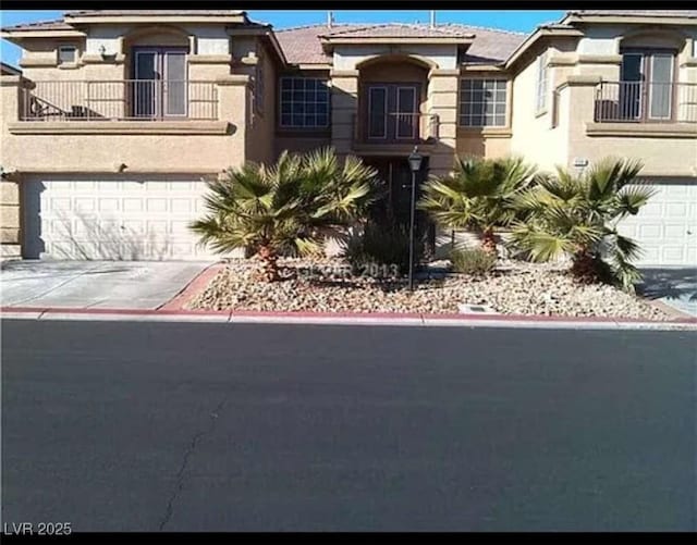 view of front of property featuring stucco siding, an attached garage, and driveway