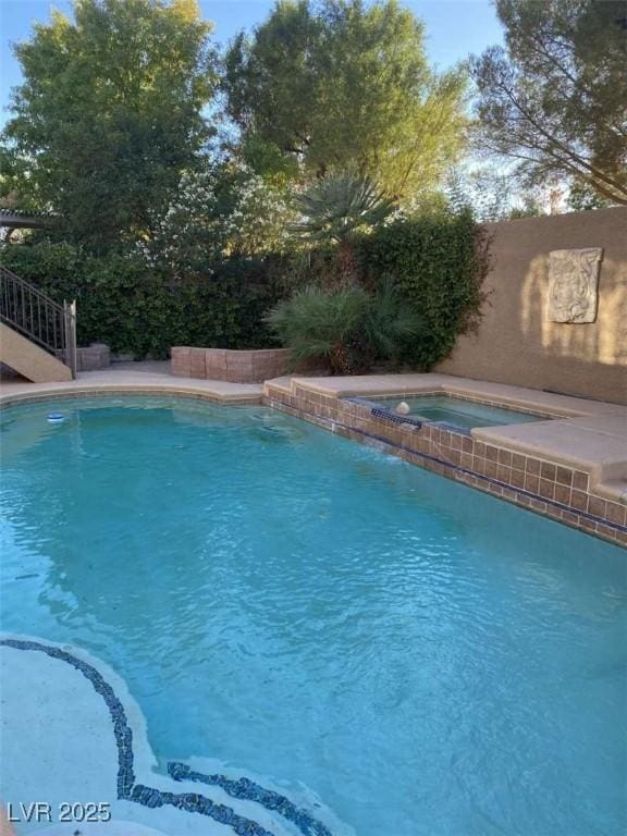 view of pool with a fenced in pool and an in ground hot tub